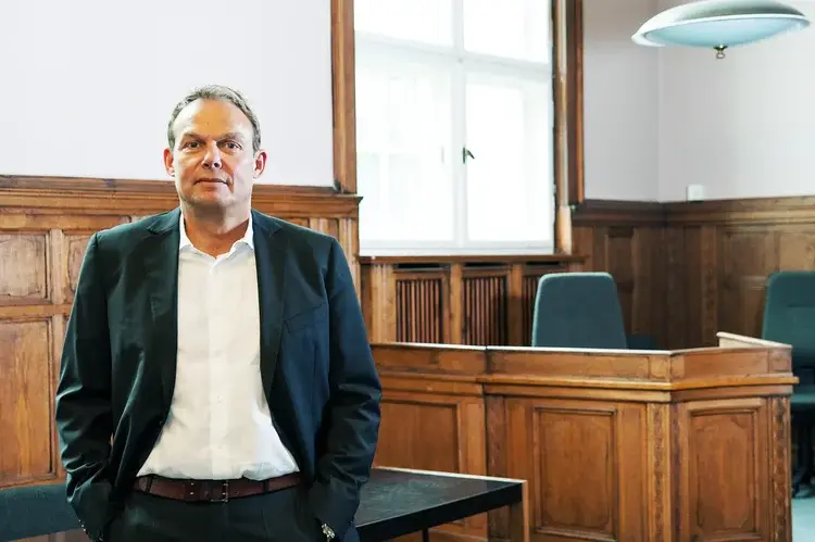 Rechtsanwalt Michael Böcker vor Holzvertäfelung